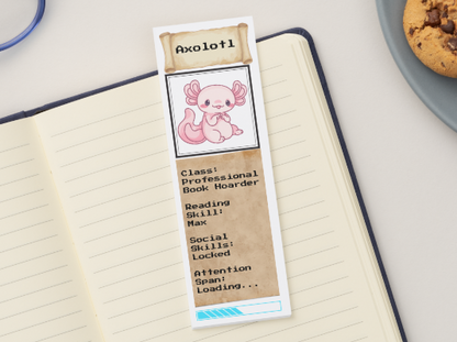 Bookmark with axolotl design on a notebook next to cookies and glasses