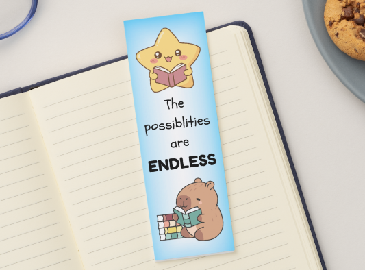 Bookmark with cartoon characters and text 'The Possibilities are ENDLESS' on a notebook with glasses and cookies in the background.