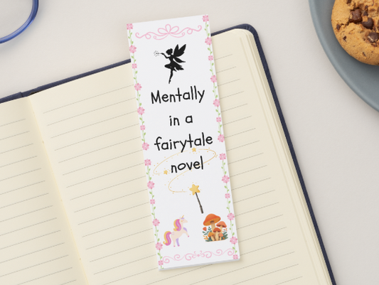 Bookmark with fairy design on a notebook next to cookies and glasses